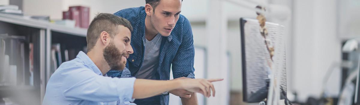 Header-Grafik IT-Experten: zwei Personen vor einem Monitor