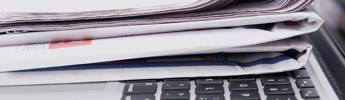 Header-Grafik Aktuelles: Zeitungsstapel mit Tastatur